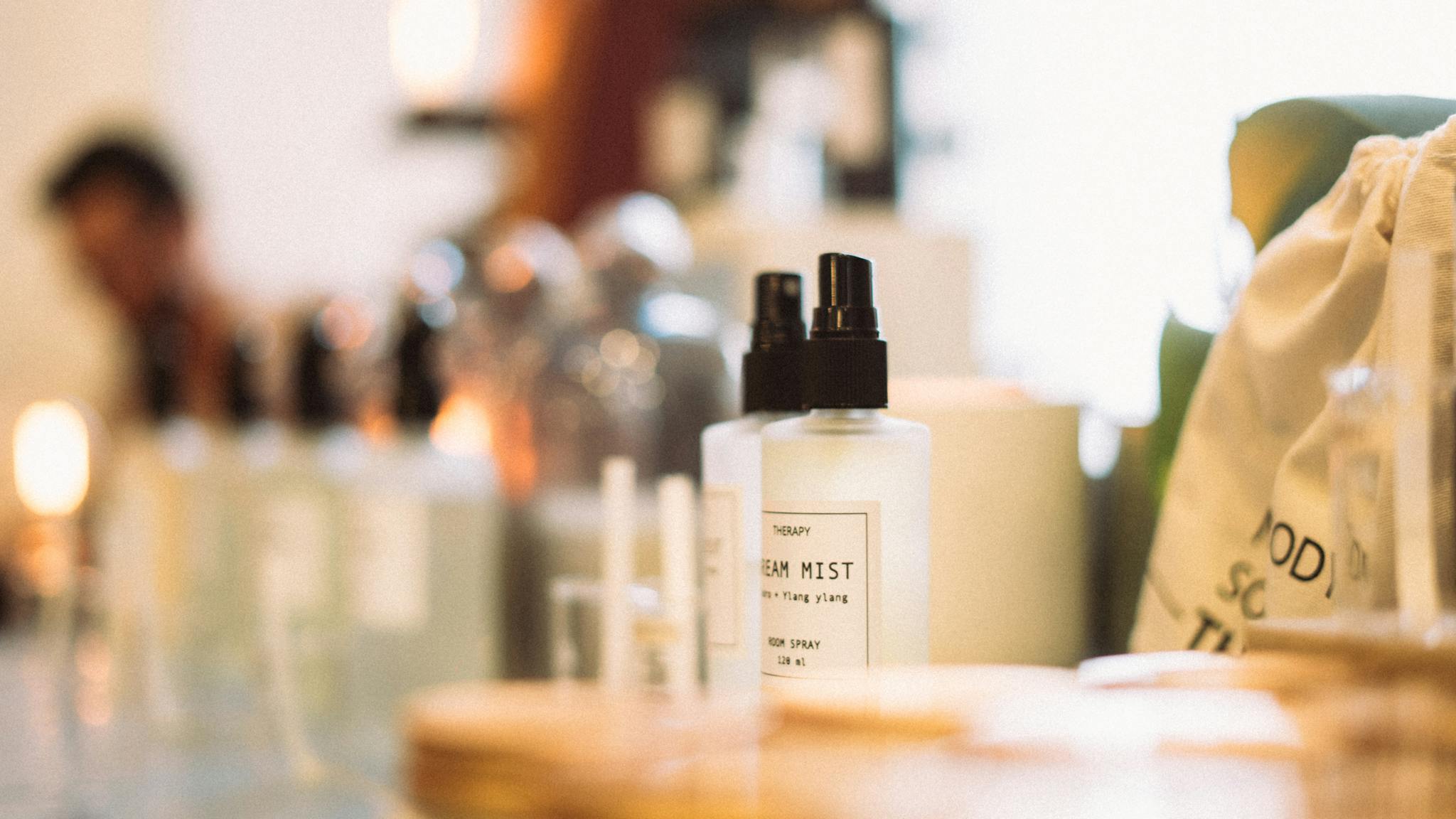 Aesthetic display of various room spray bottles with soft focus lighting.