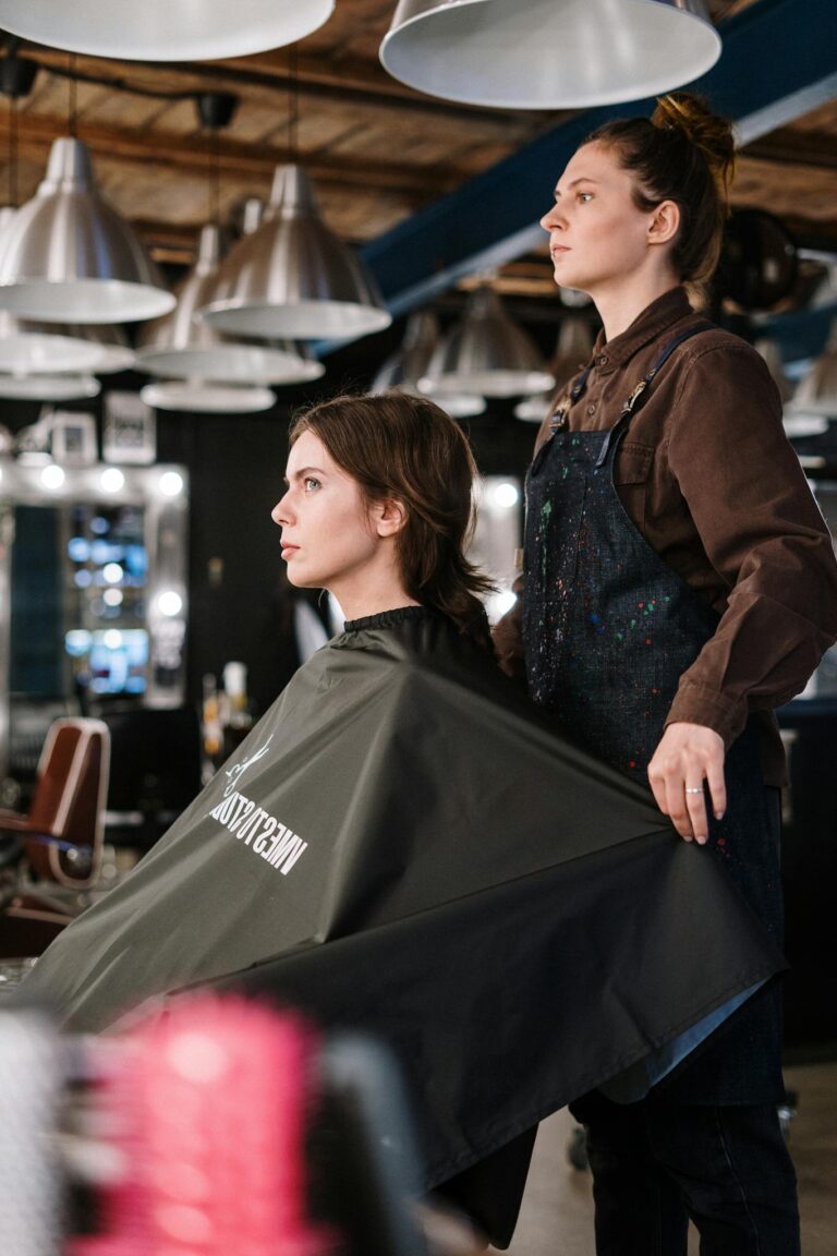 Professional hairstylist preparing a client at a modern hair salon, showcasing expertise and style.